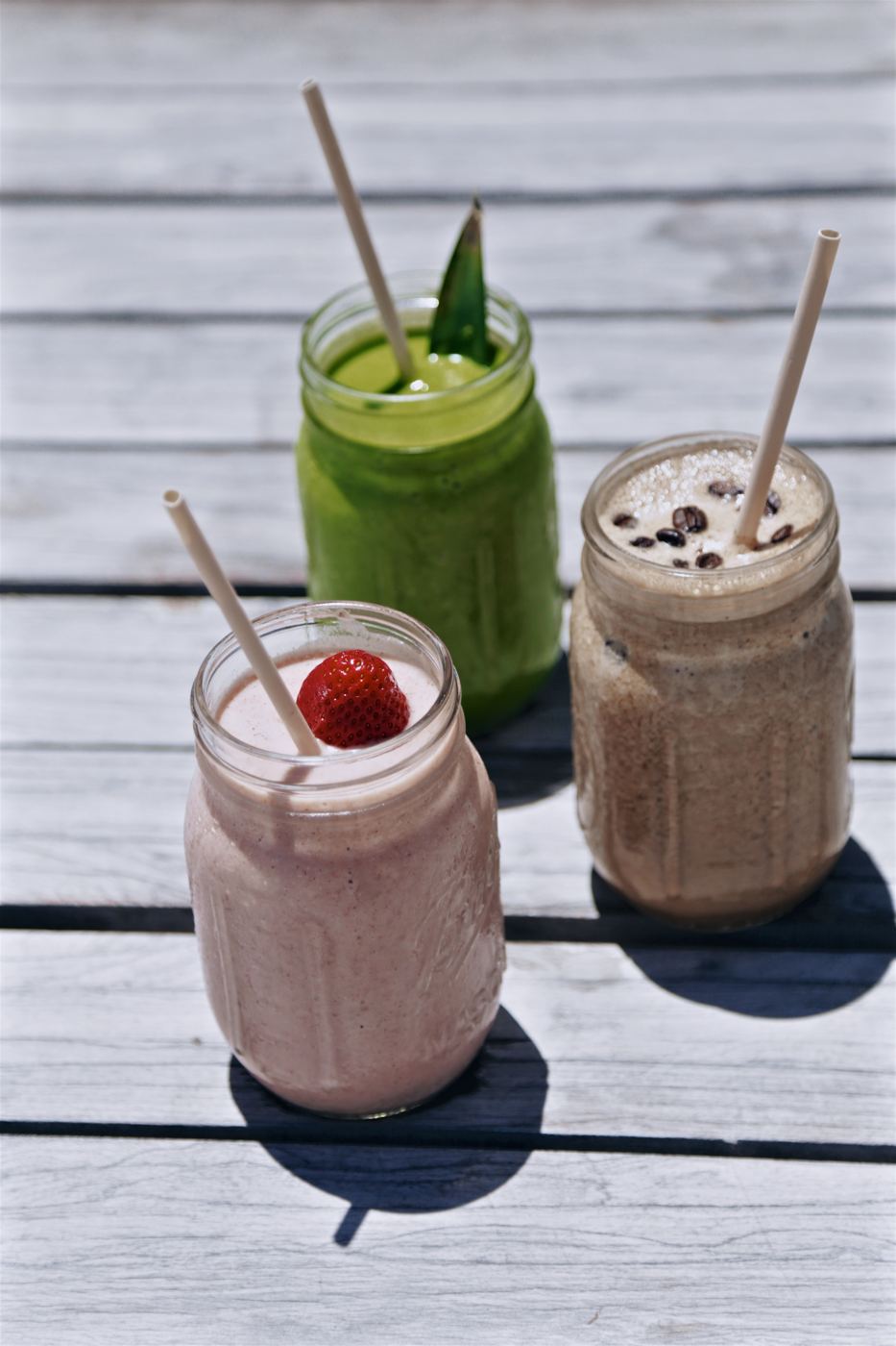 Three smoothies in jars on the deck